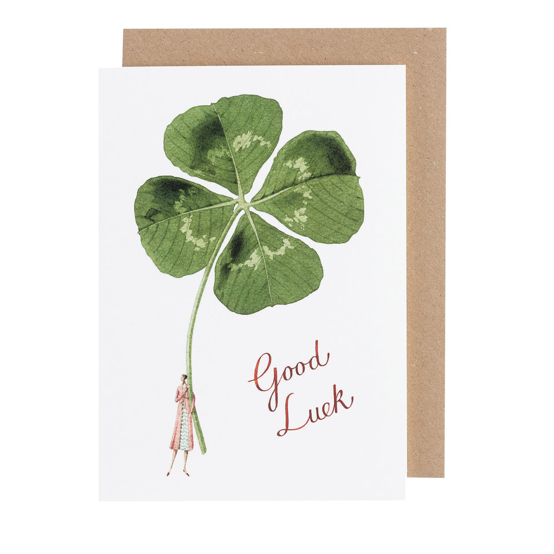 A white greeting card featuring a stylized illustration of a woman holding a gigantic four-leafed clover with &quot;Good Luck&quot; written in beautiful script, with the included kraft paper envelope.