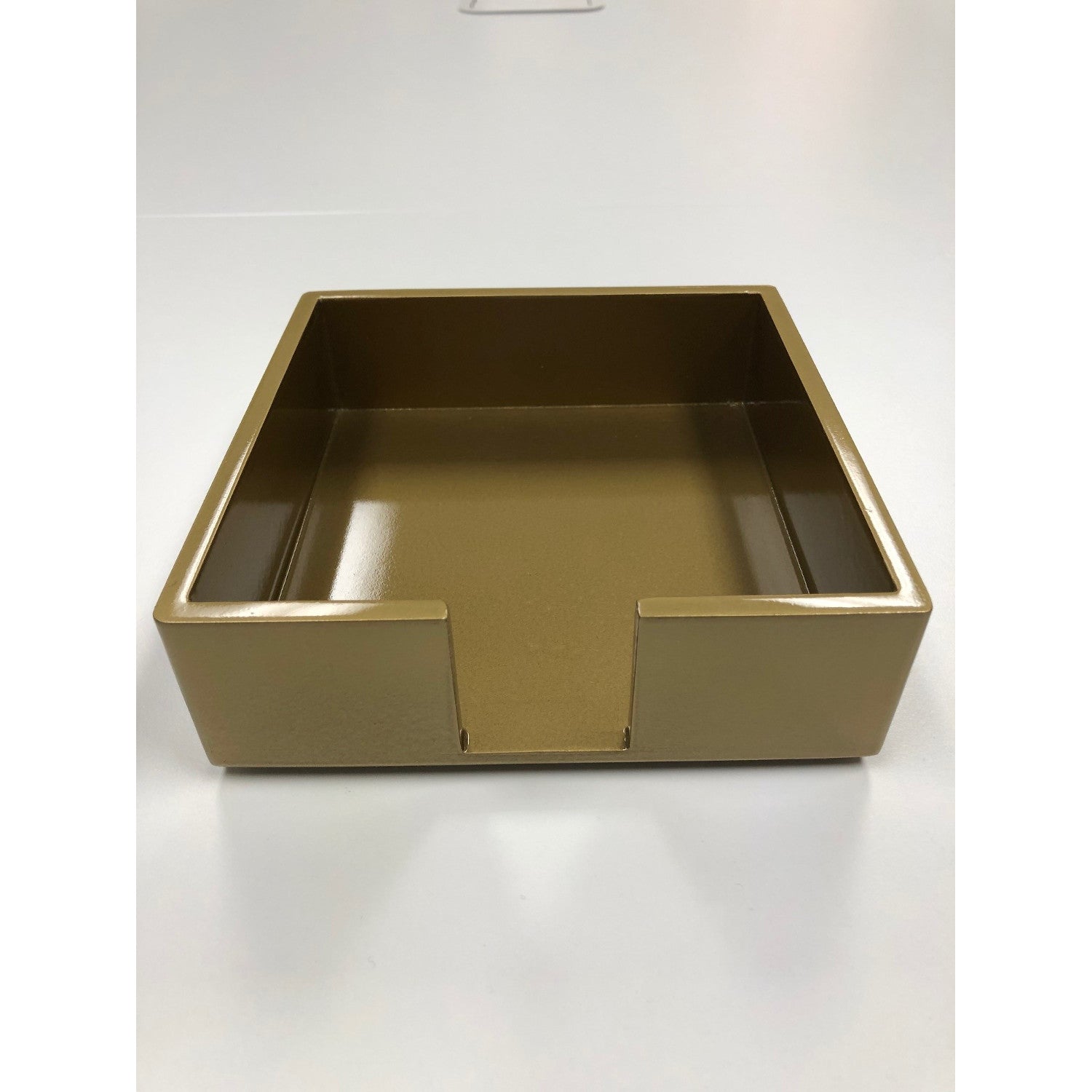 A gold lacquered cocktail napkin holder.