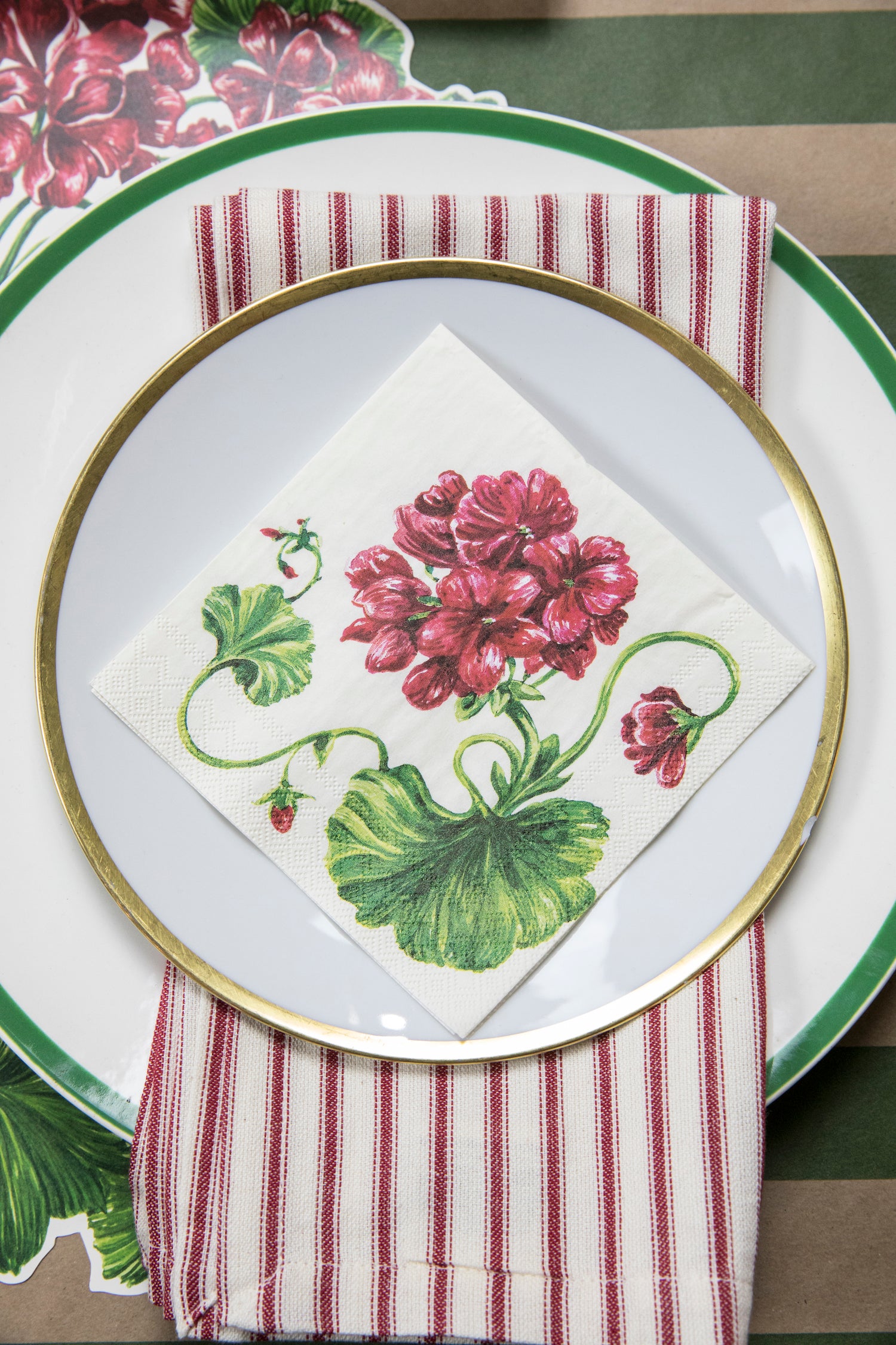 An elegant place setting from above, featuring a Geranium Cocktail Napkin on the plate.