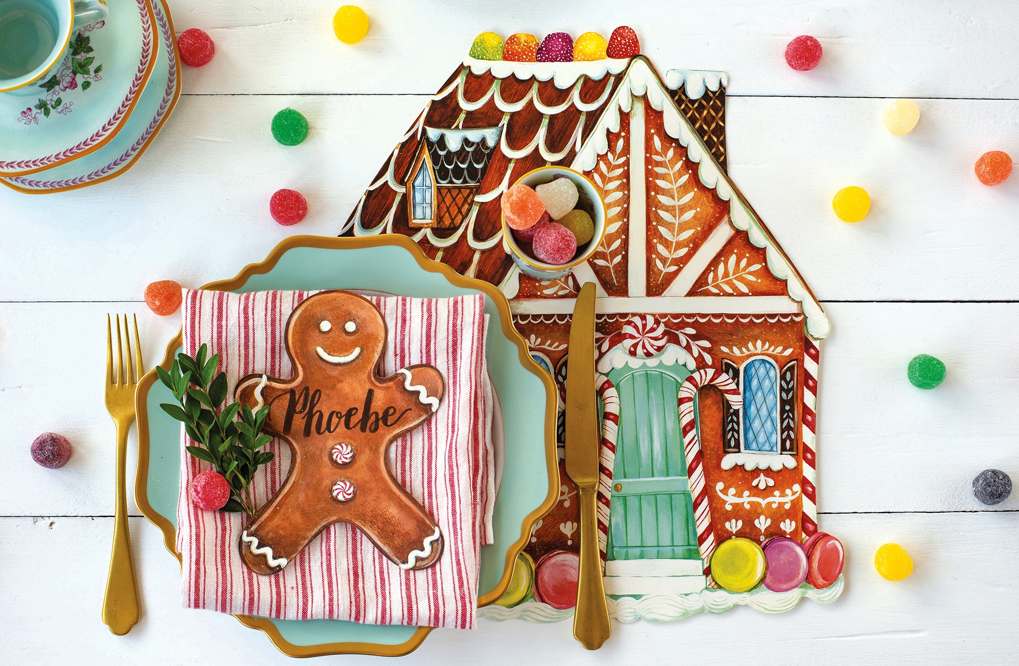 A whimsical holiday place setting featuring a Gingerbread Man Table Accent labeled "Phoebe" resting on the plate.