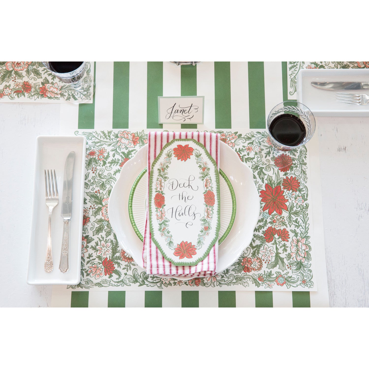 A Christmas place setting featuring a Christmas China Table Accent with "Deck the Halls" written on it in beautiful script.