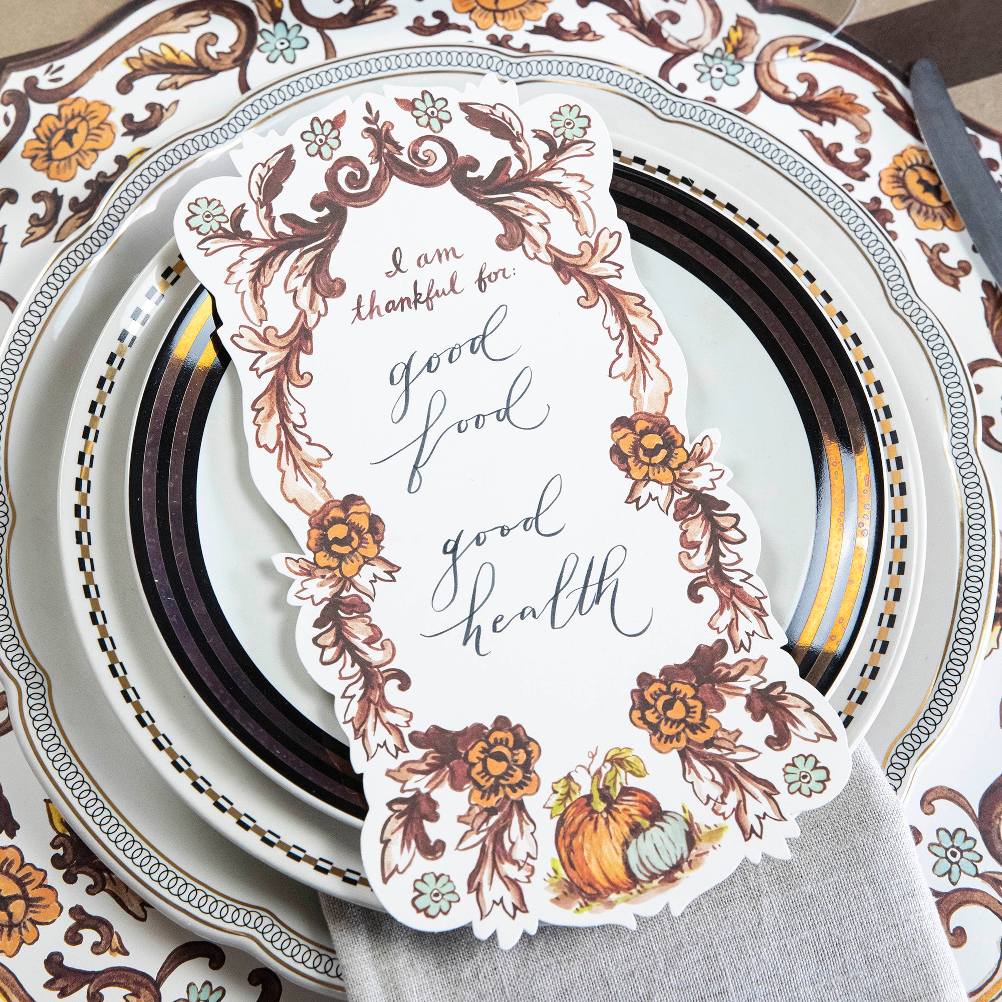 Close-up of an elegant Thanksgiving place setting featuring an "I Am Thankful For" Table Accent resting on the plate.