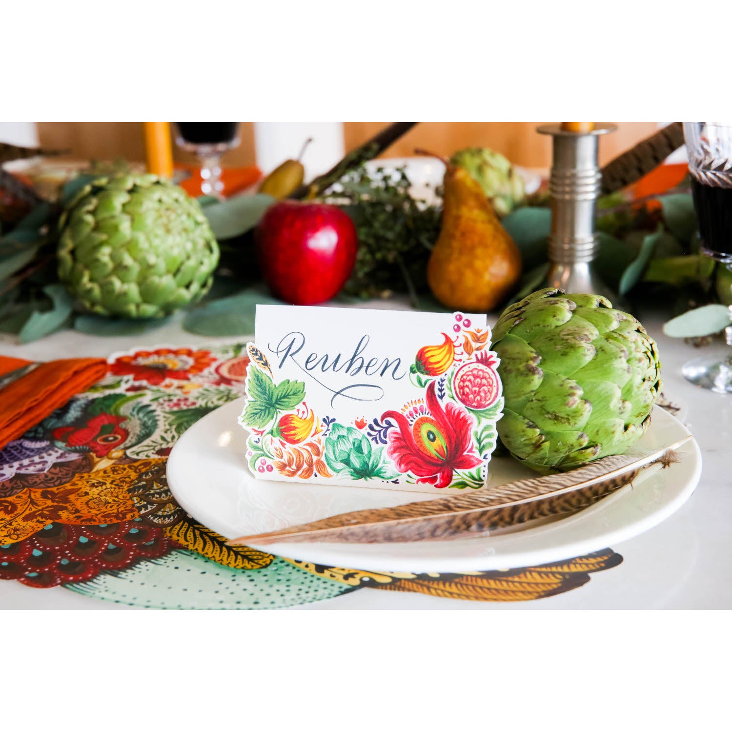 A Bountiful Place Card, reading "Ruben", on the plate of an elegant fall-themed place setting.