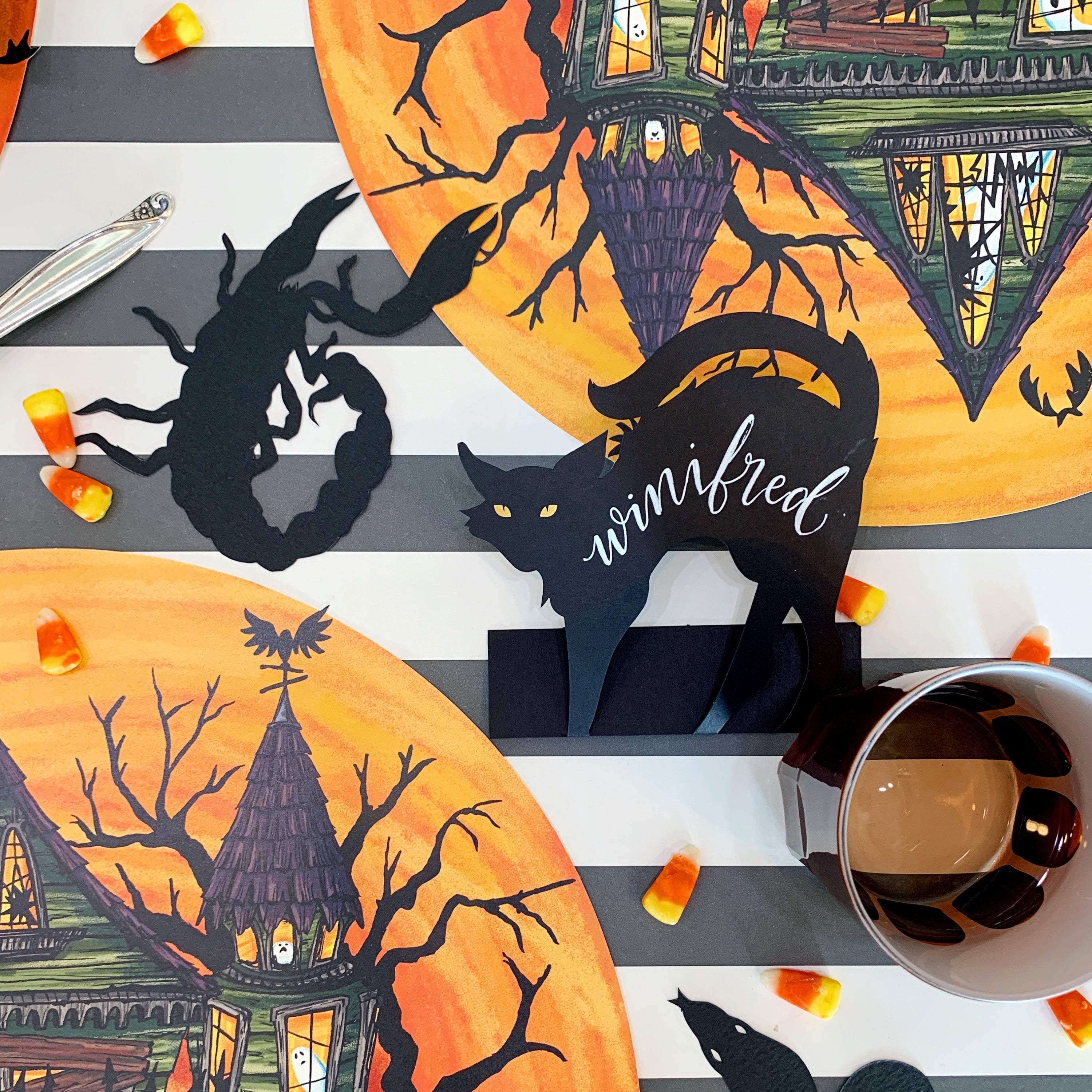 A Black Cat Place Card, reading "Winifred" in white ink, as part of a spooky Halloween table setting.