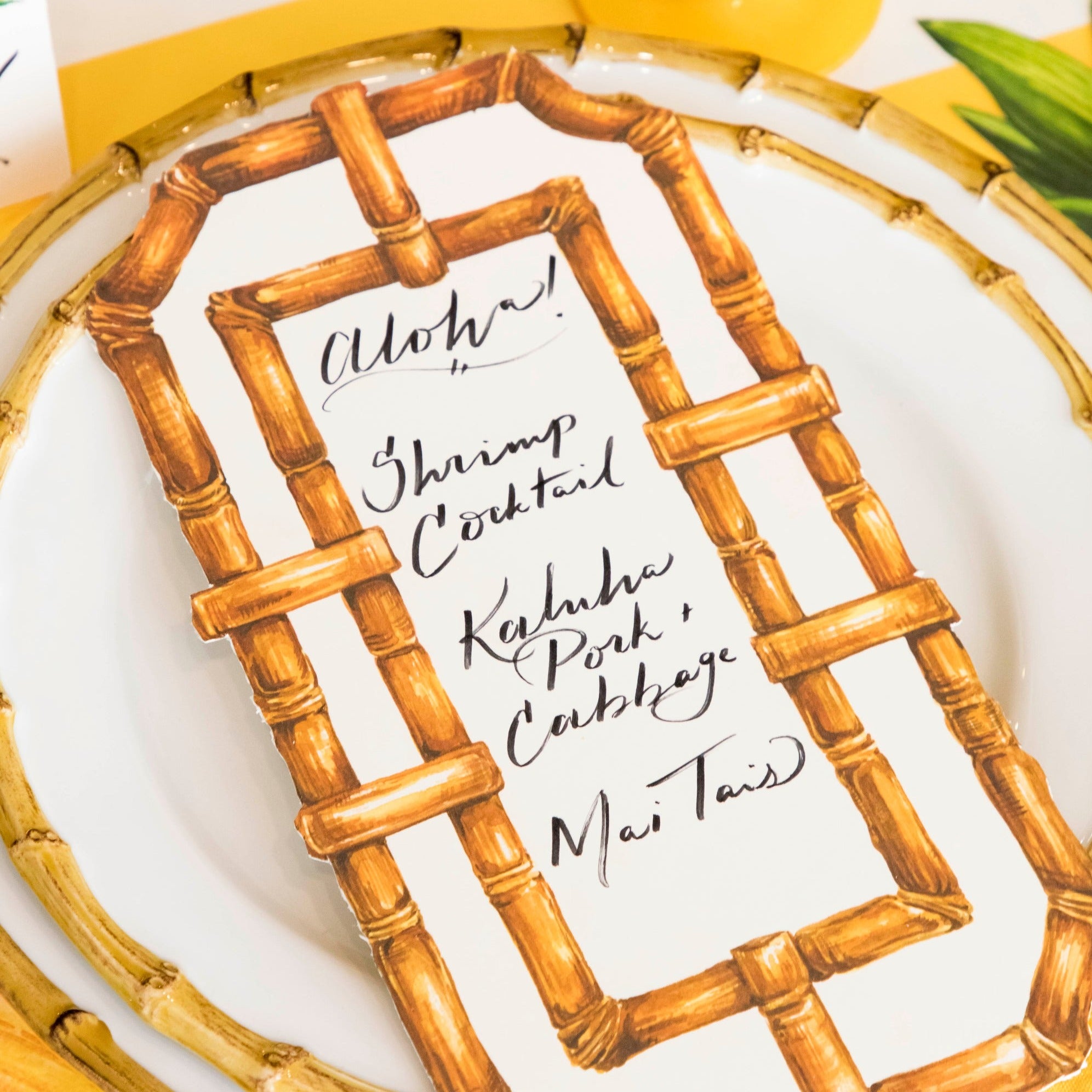 Close-up of a Bamboo Table Card with a menu written on it resting on a plate.