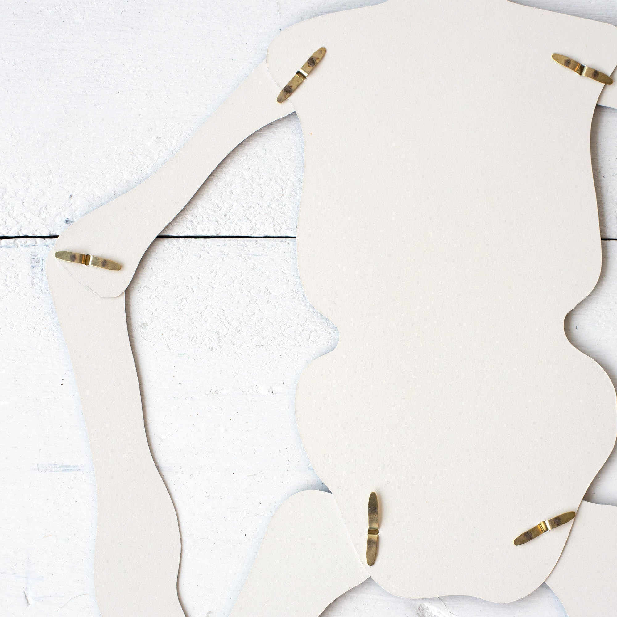 Close-up of the back side of the Articulated Skeleton Decorative Accent, showing the white paper and the brads holding the joints together.