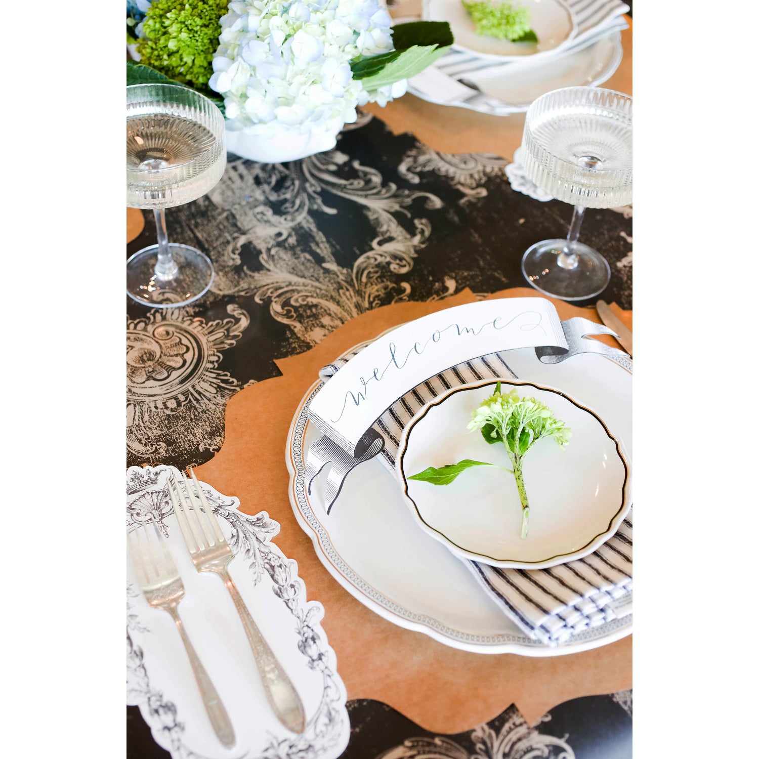 An elegant place setting featuring the cutlery resting on a Flourish Frame Table Accent to the left of the plate.