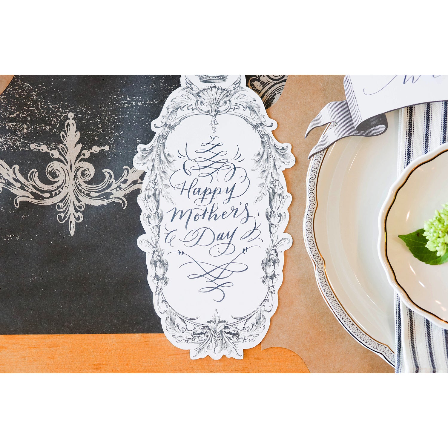An elegant place setting featuring a Flourish Frame Table Accent with "Happy Mother&