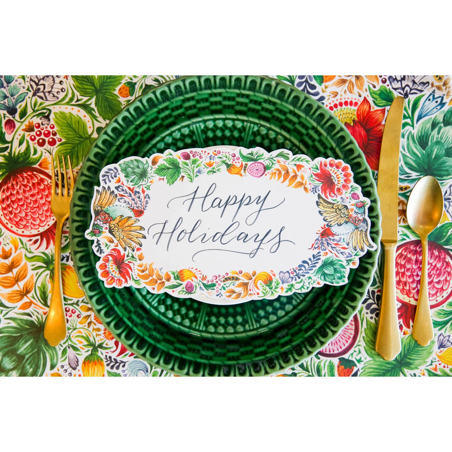 A vibrant place setting featuring a Bountiful Frame Table Accent reading "Happy Holidays" adorning the plate, from above.