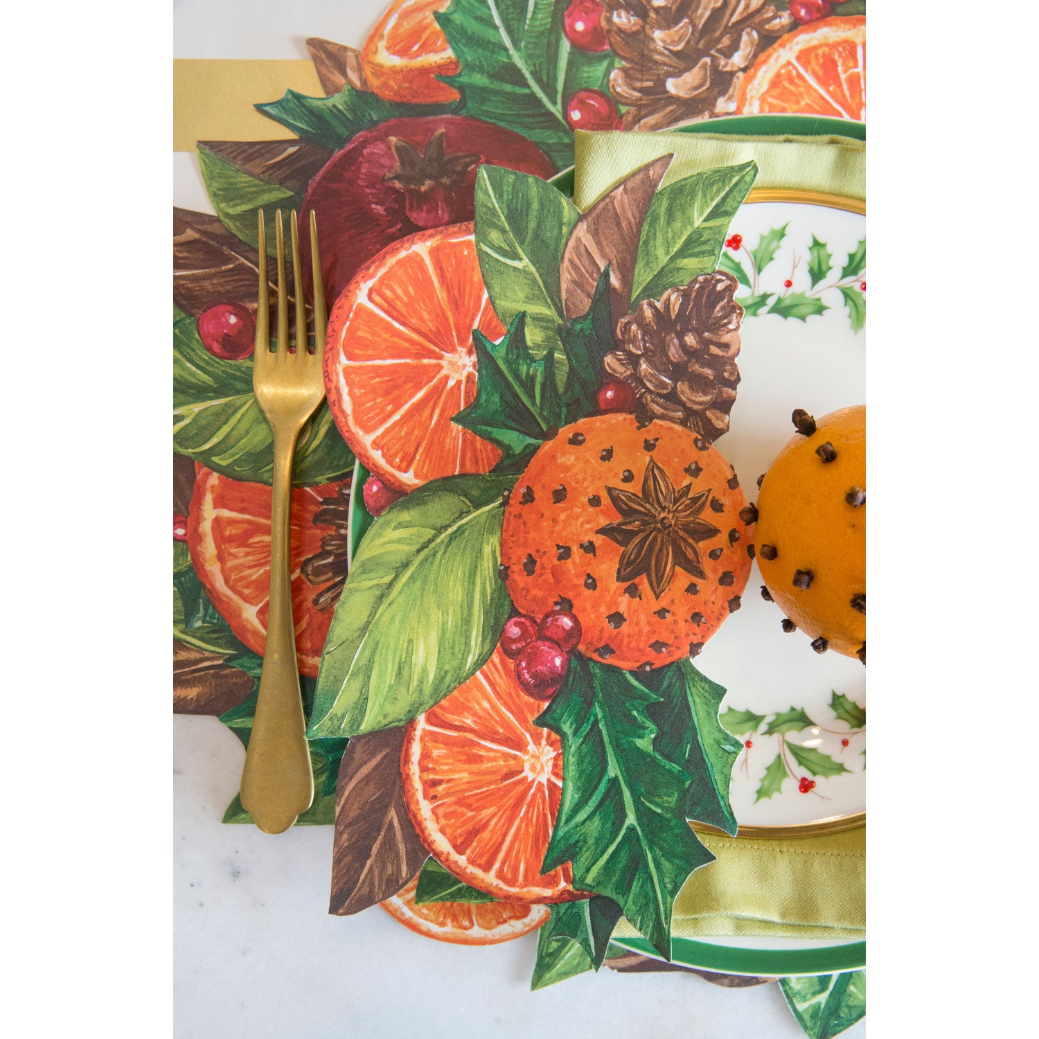 A festive wintertime place setting featuring a Pomander Table Accent resting on the plate.