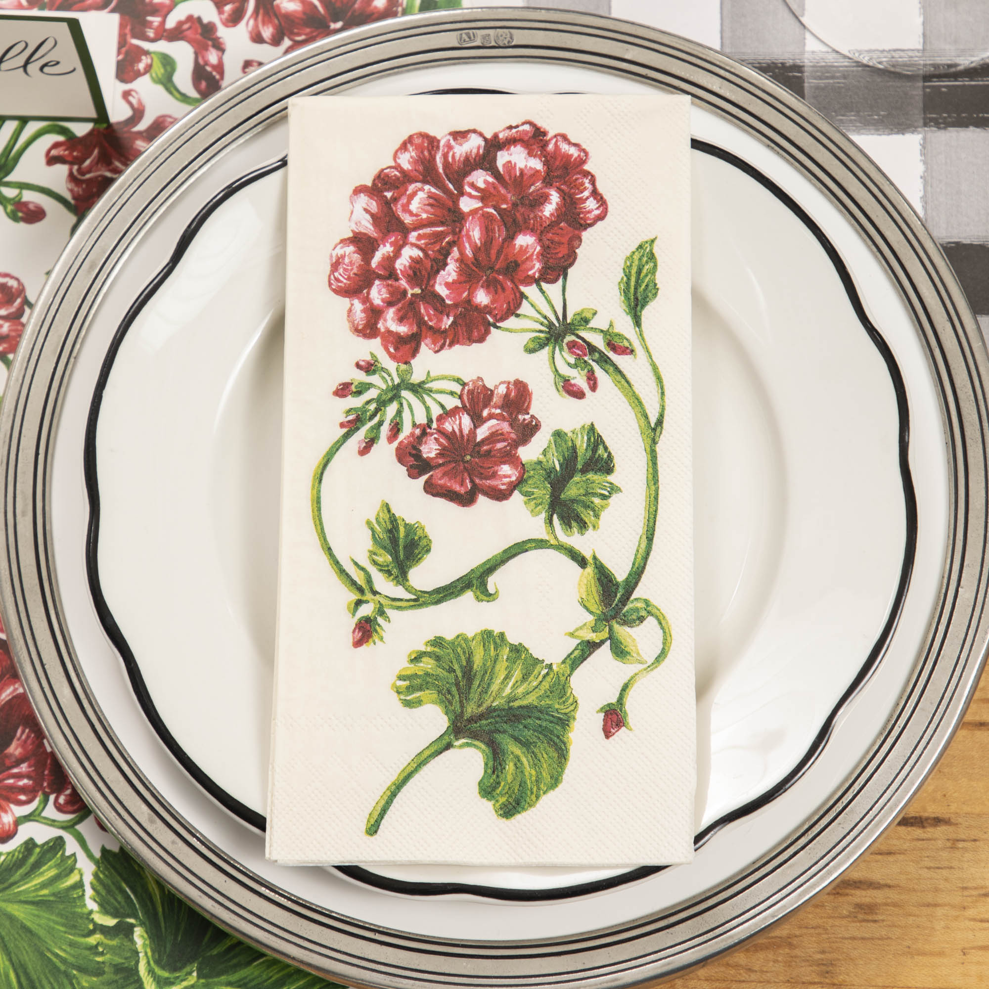 An elegant place setting from above, featuring a Geranium Guest Napkin on the plate.