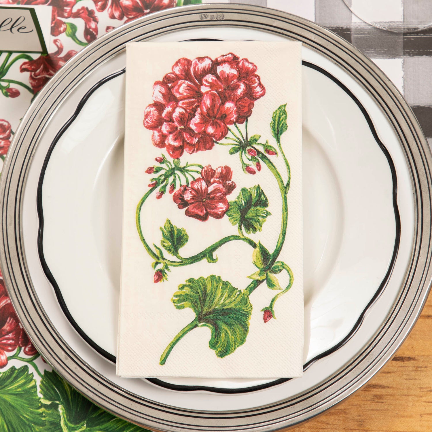 An elegant place setting from above, featuring a Geranium Guest Napkin on the plate.