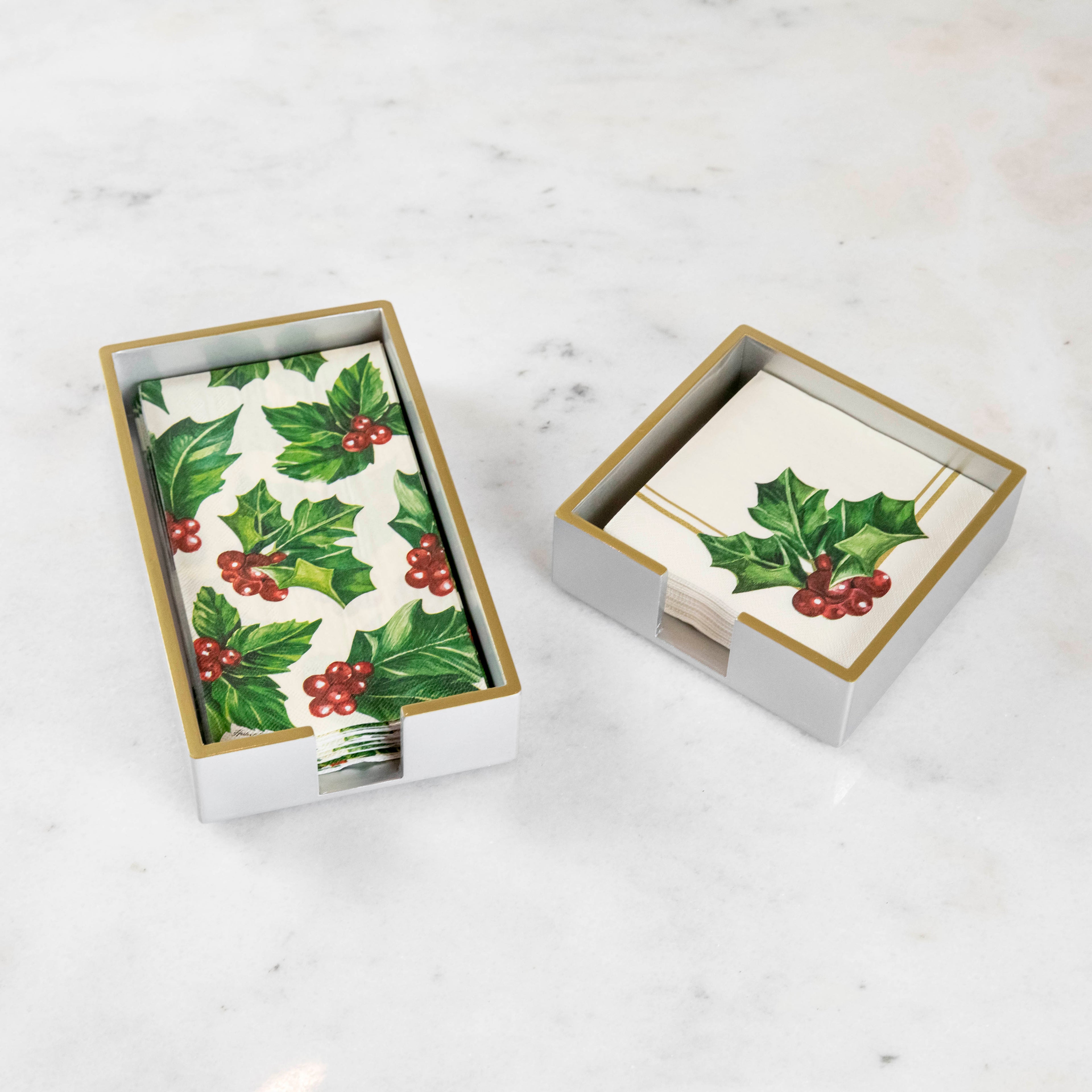 Silver lacquered guest and cocktail napkin holders with napkins inside.