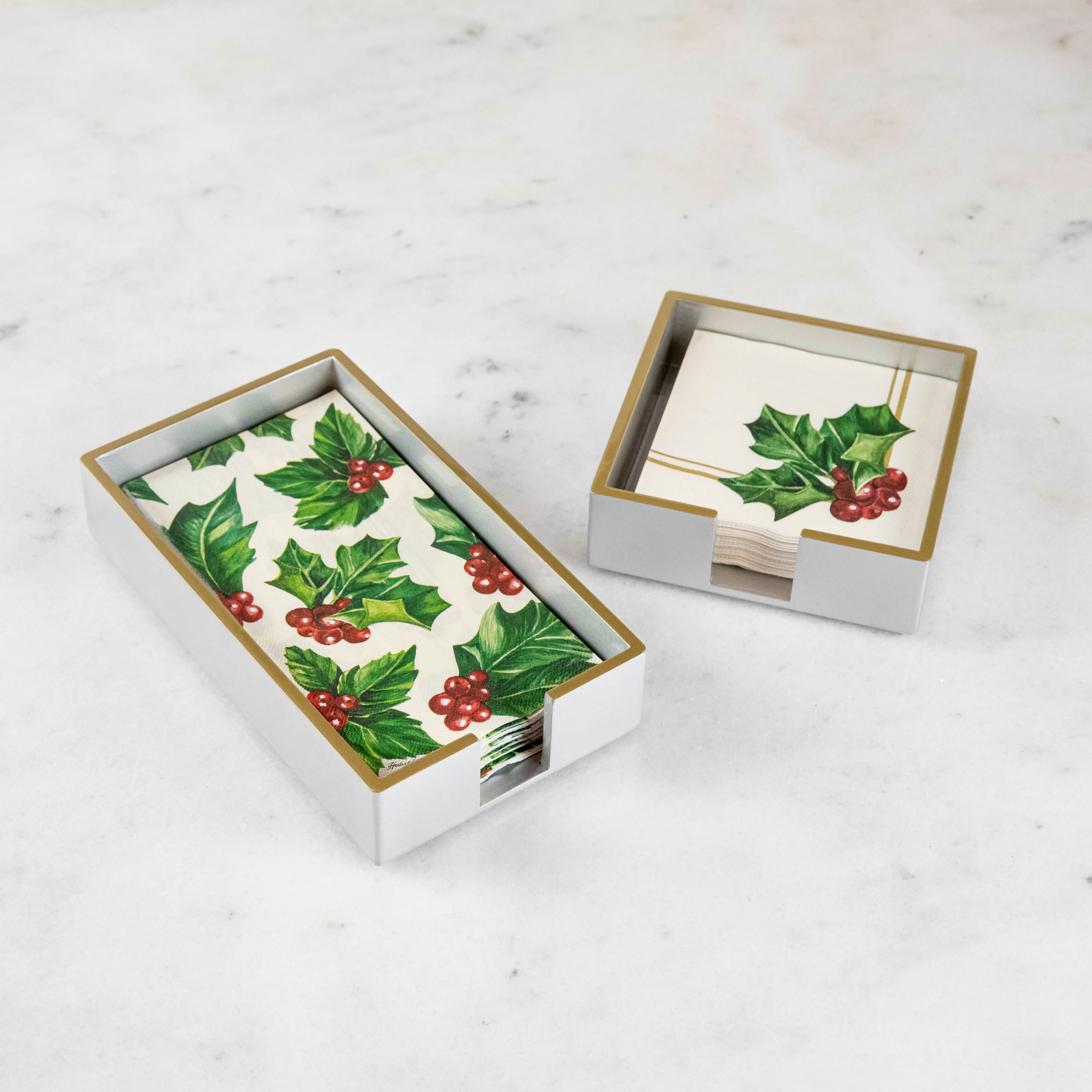 Silver lacquered guest and cocktail napkin holders with napkins inside.