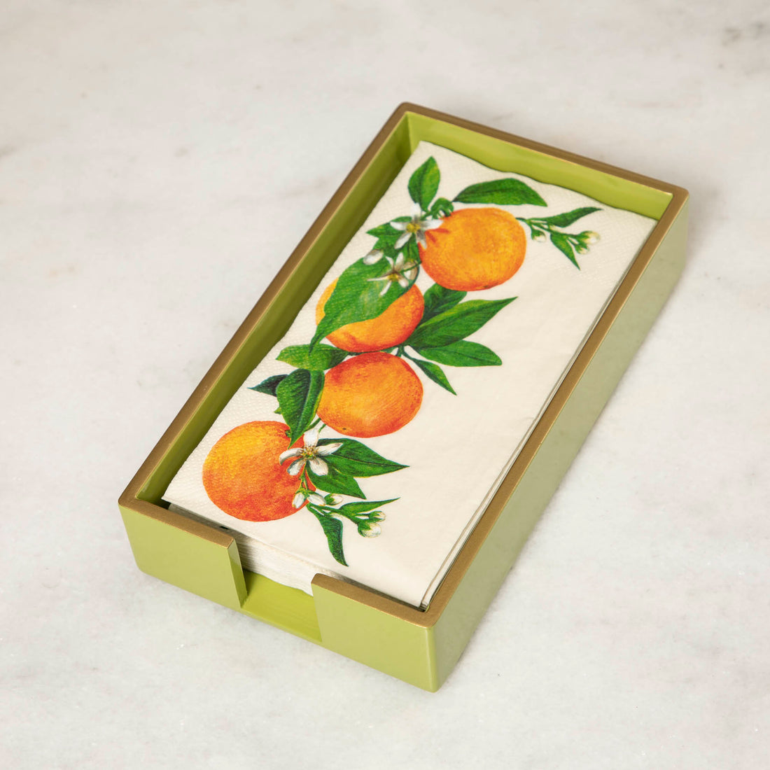 A green lacquered wood beverage napkin caddy with gold trim, featuring a napkin  with an orange pattern.