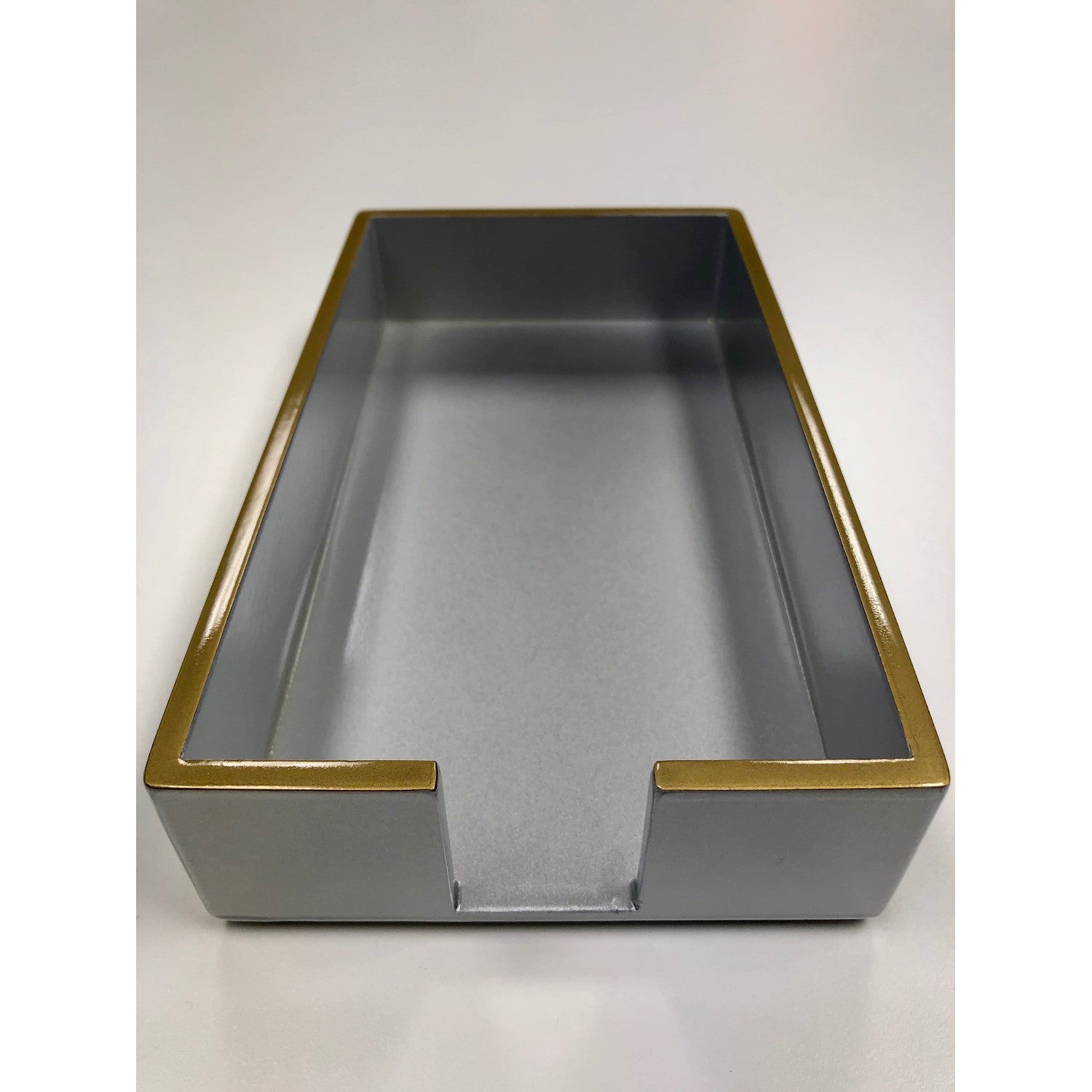A silver lacquered guest napkin holder with gold trim.