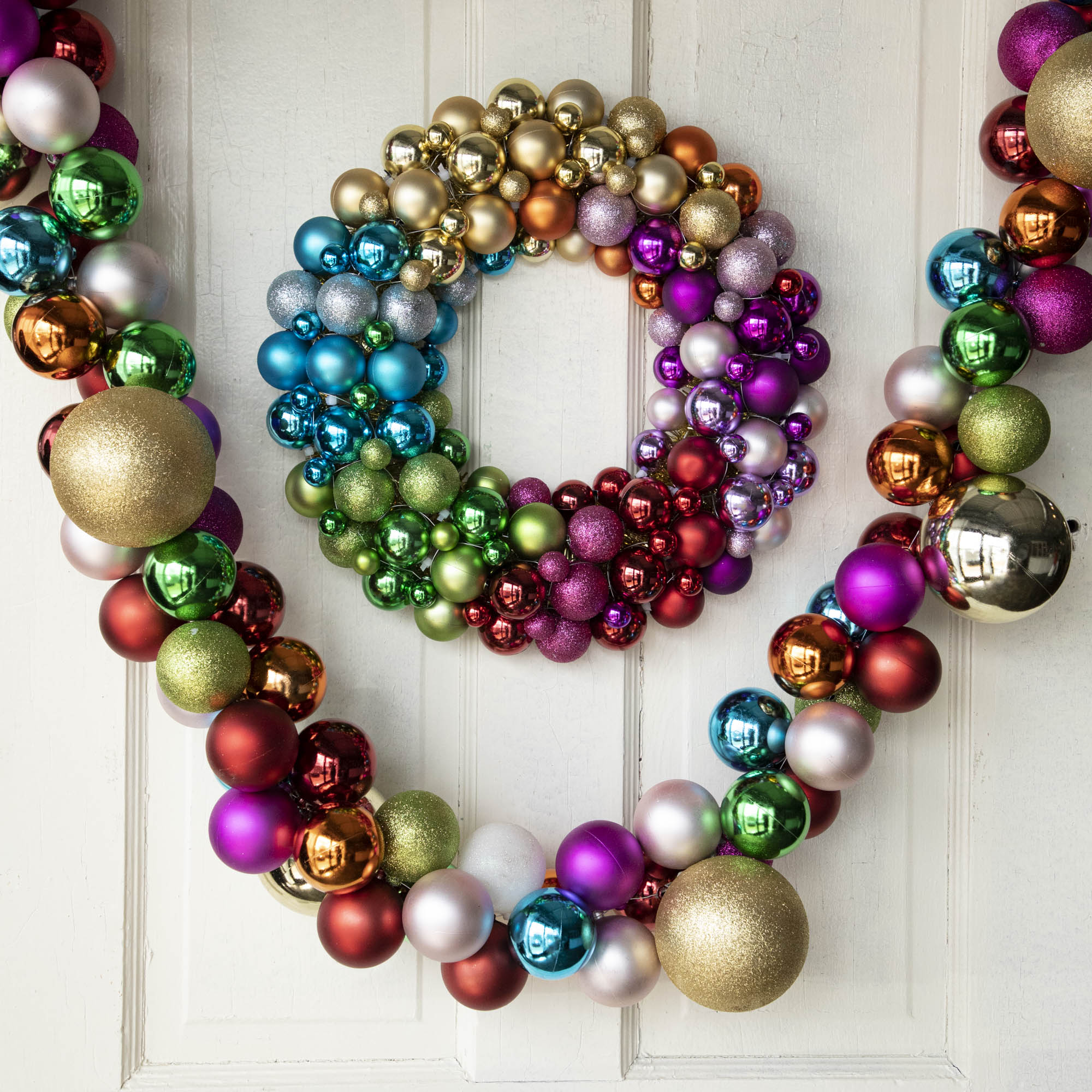 Collected Ornament Garland with oversized multicolored balls hanging with a corresponding wreath. 
