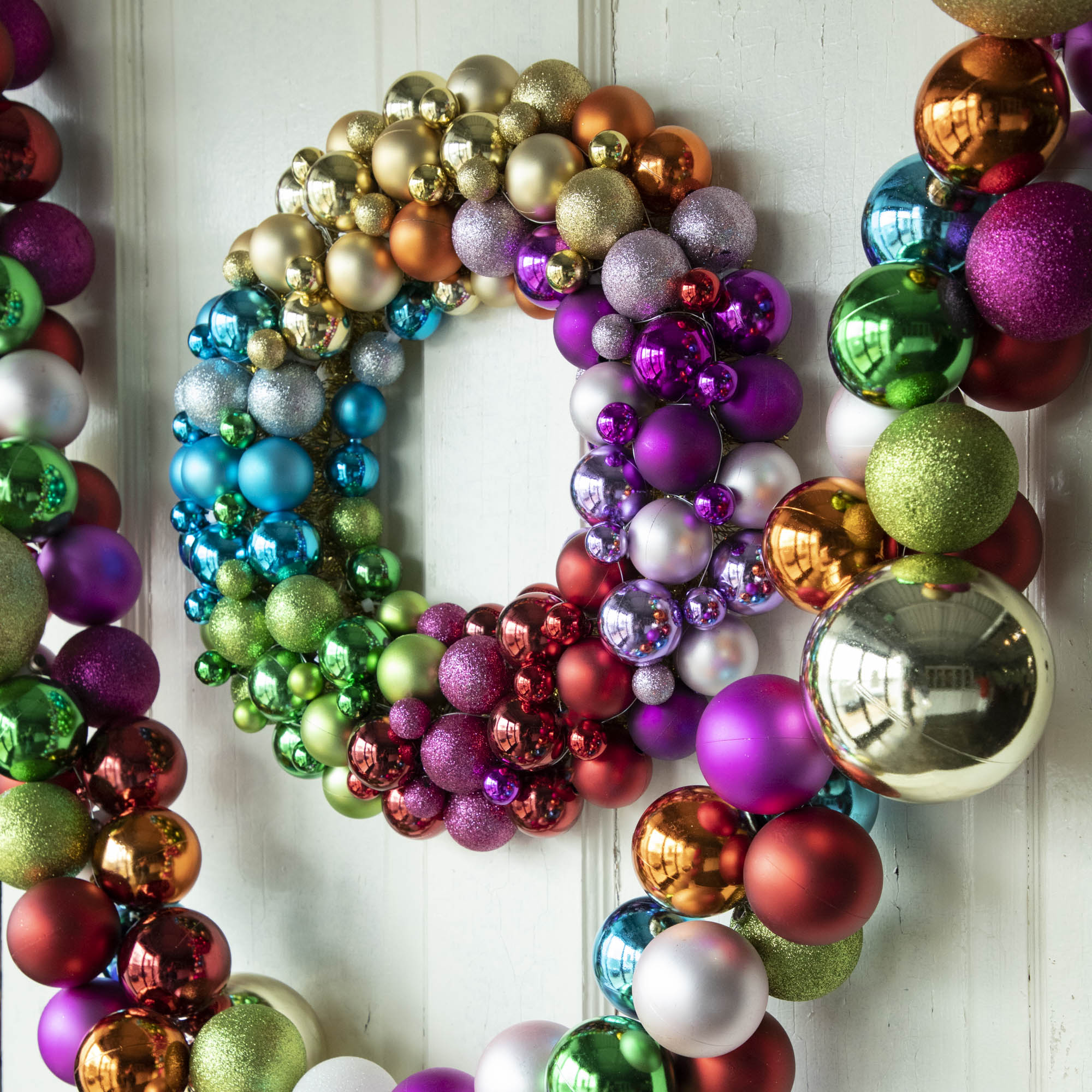 Collected Ornament Garland with oversized multicolored balls hanging with a corresponding wreath.