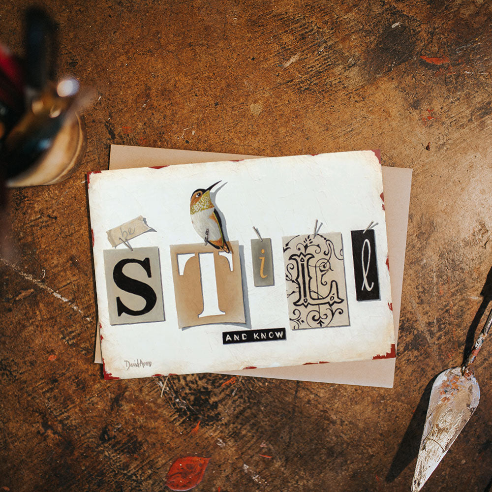 Handcrafted &quot;Be Still &amp; Know&quot; (Tags) notecard of a hummingbird perched on the word &quot;style&quot; written in unique typography on textured paper, accompanied by art tools on a worn surface by David Arms.