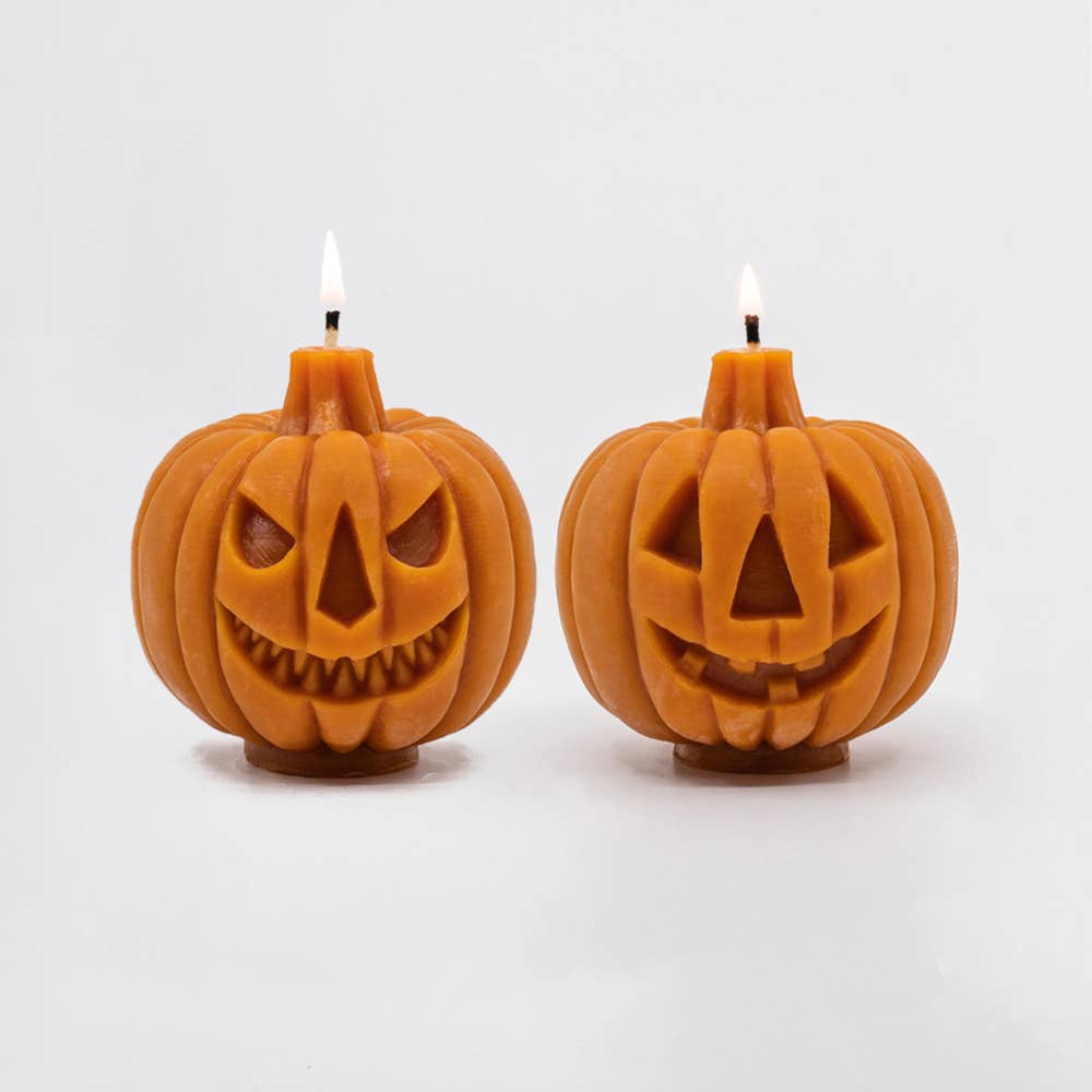 Both sides of the Jack-o-lantern candle, showing the scary face and the happy face.