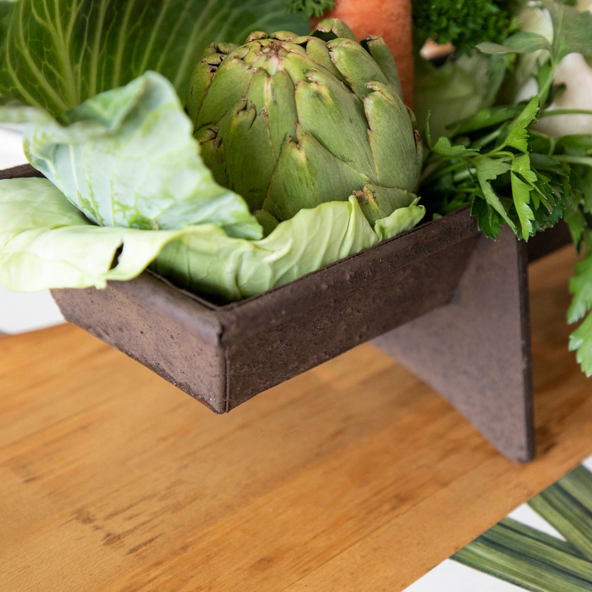A table with a tray of vegetables on it, featuring a Park Hill Chicken Feeder Centerpiece in rustic style as the centerpiece.
