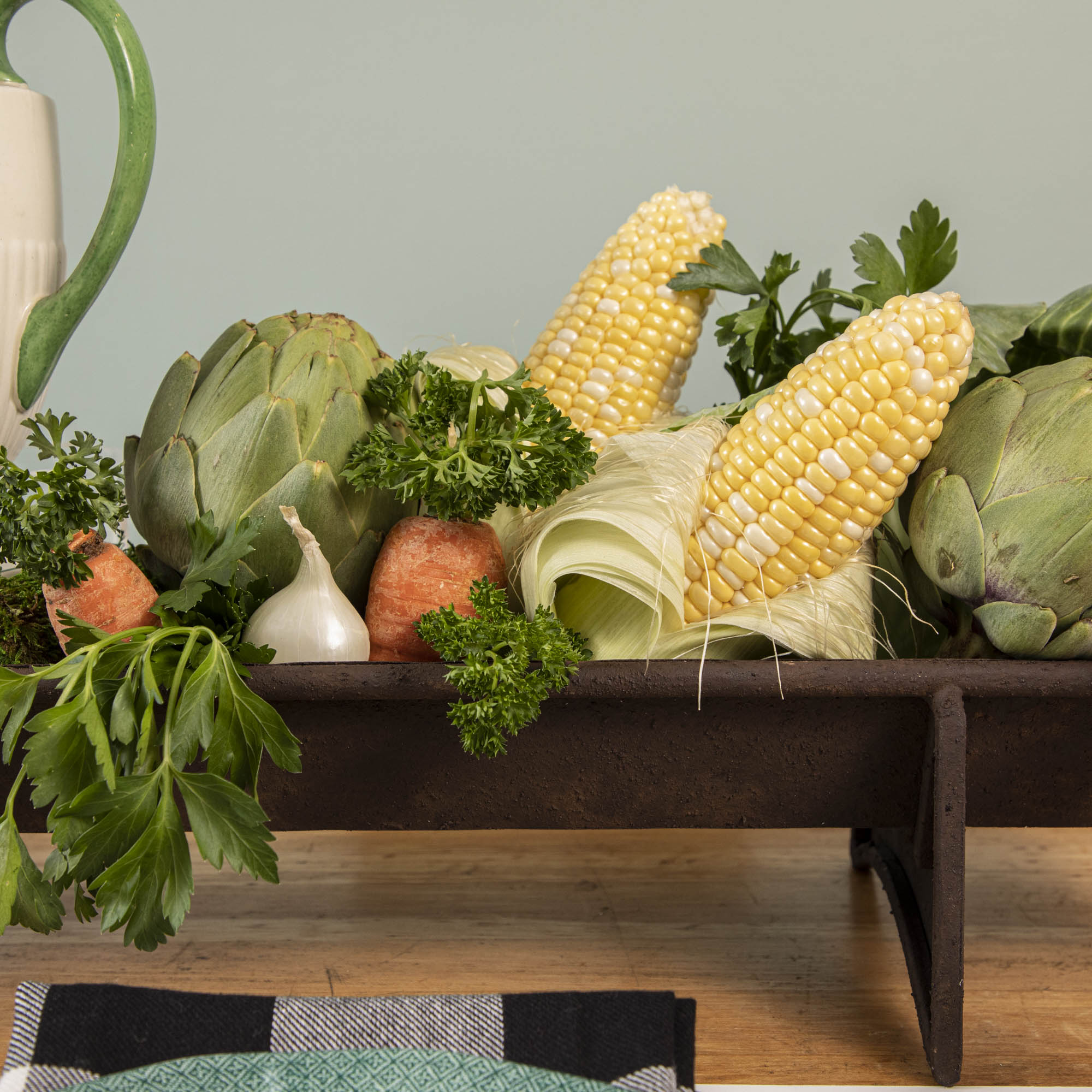 A table with a tray of vegetables on it, featuring a Park Hill Chicken Feeder Centerpiece in rustic style as the centerpiece.