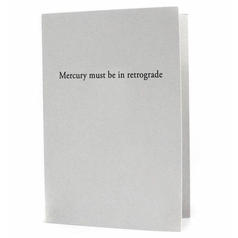 A grey cotton paper card from Oblation Paper & Press with the text "Mercury Must Be In Retrograde" letterpress printed on the front.