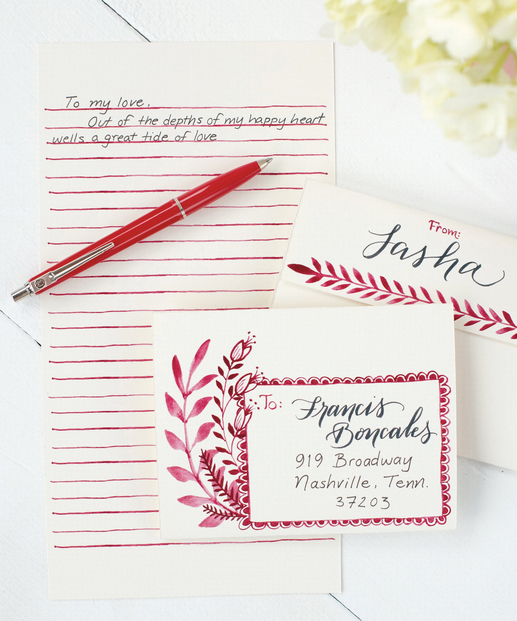 A Love Letter Fold Note Card with red flowers and leaves on a beige background, ready to fold and mail from Hester & Cook.