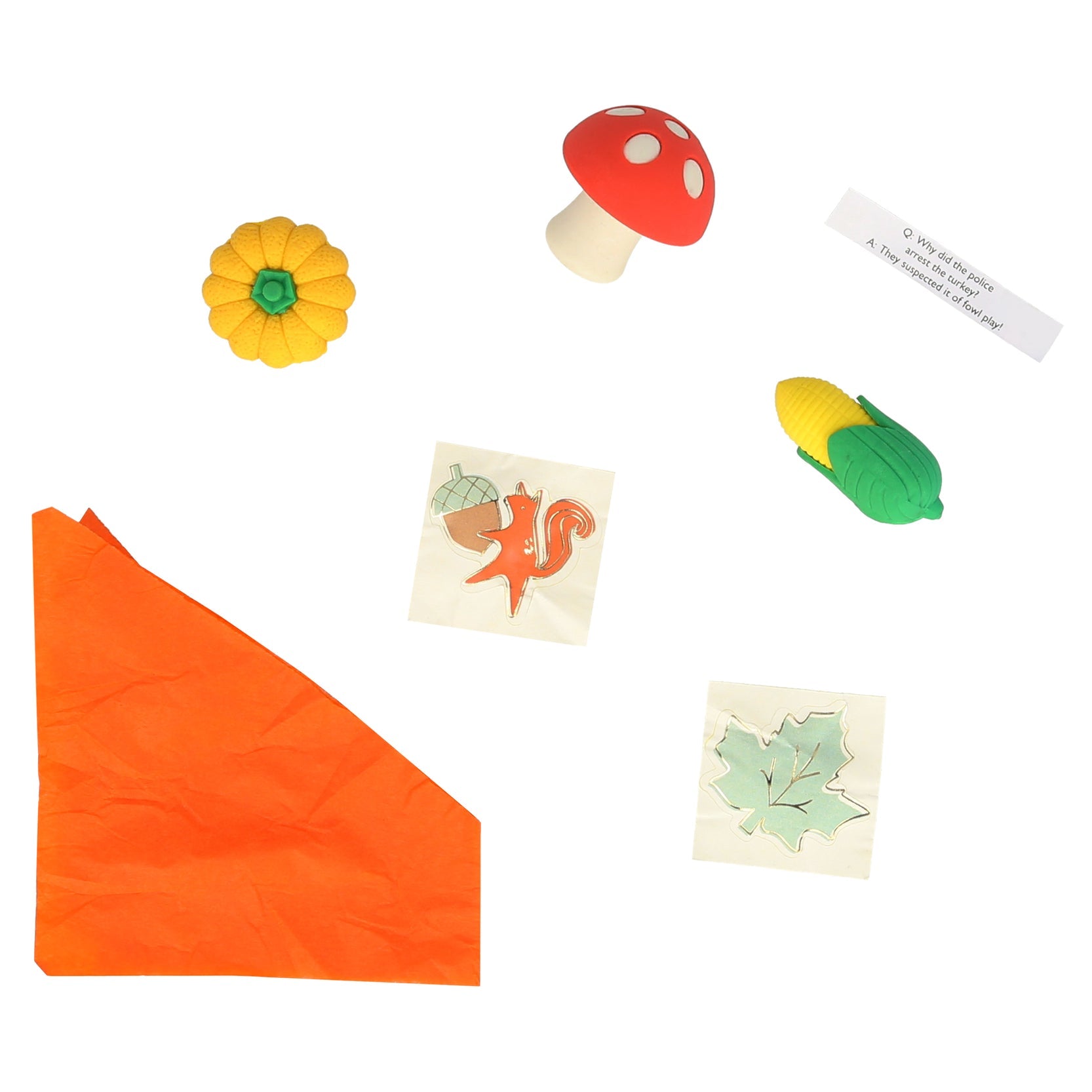 An orange tissue paper party hat, a sticker with a fox holding an acorn, a sticker of a maple leaf, a joke and three different erasers; a mushroom, a corn, and a pumpkin