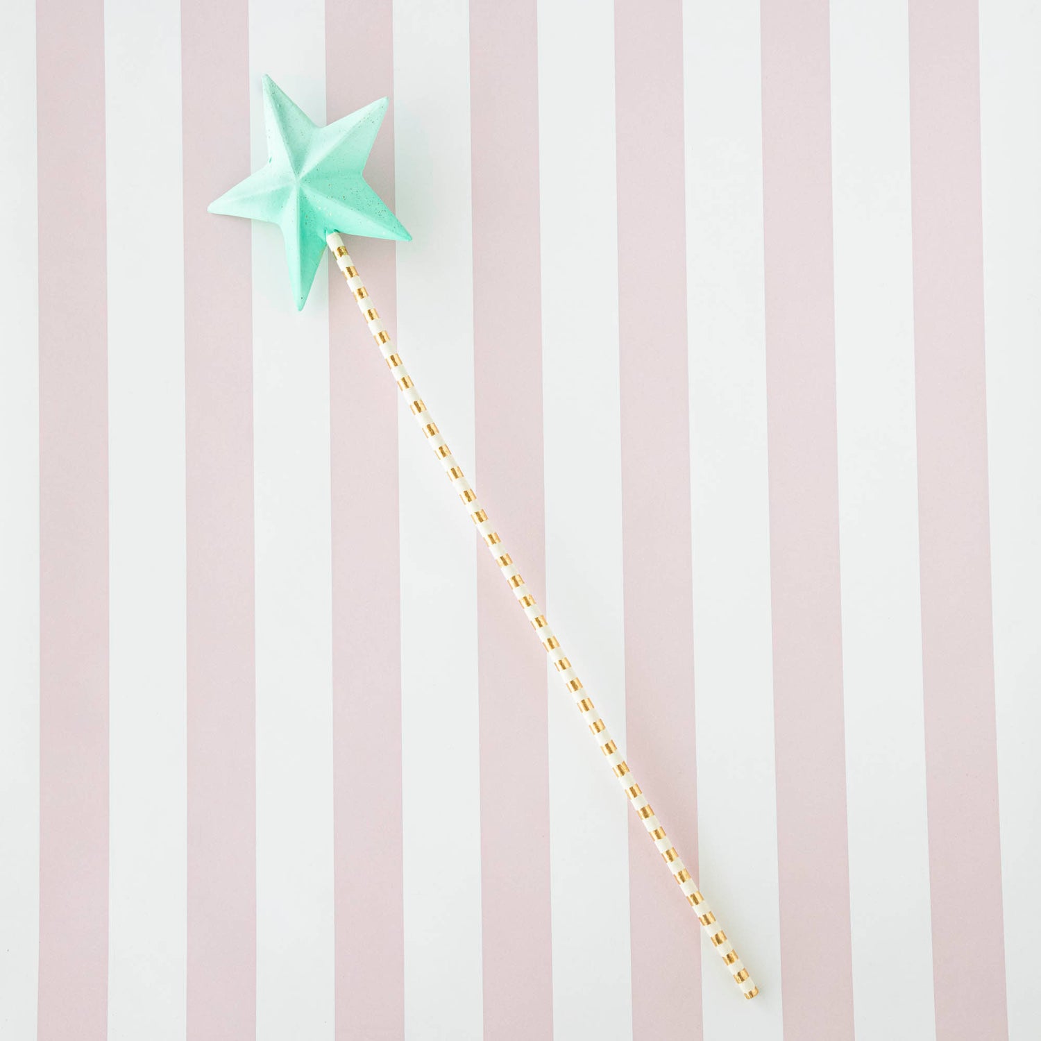 Five Glitterville Magic Wands on a striped background.