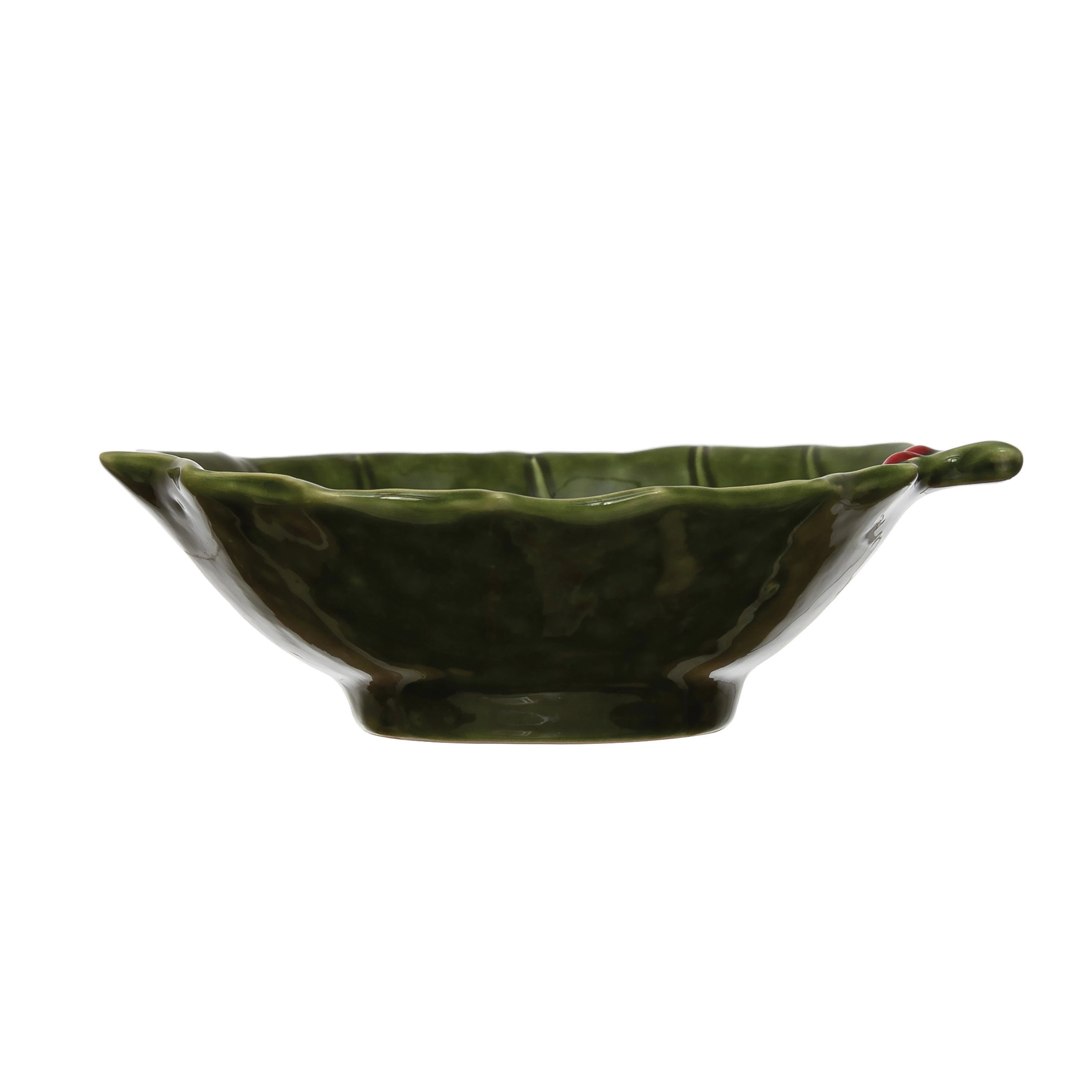 A green stoneware bowl with a holly leaf pattern.