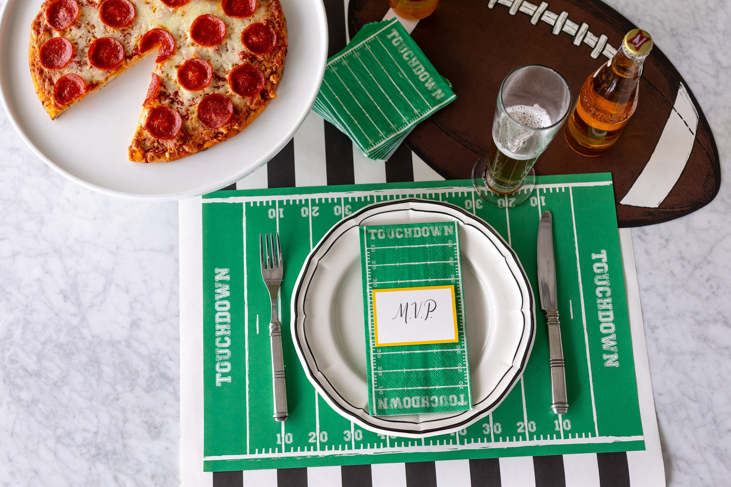 A tailgate themed table setting featuring the Touchdown Placemat and napkins and Die-cut Football Placemat.