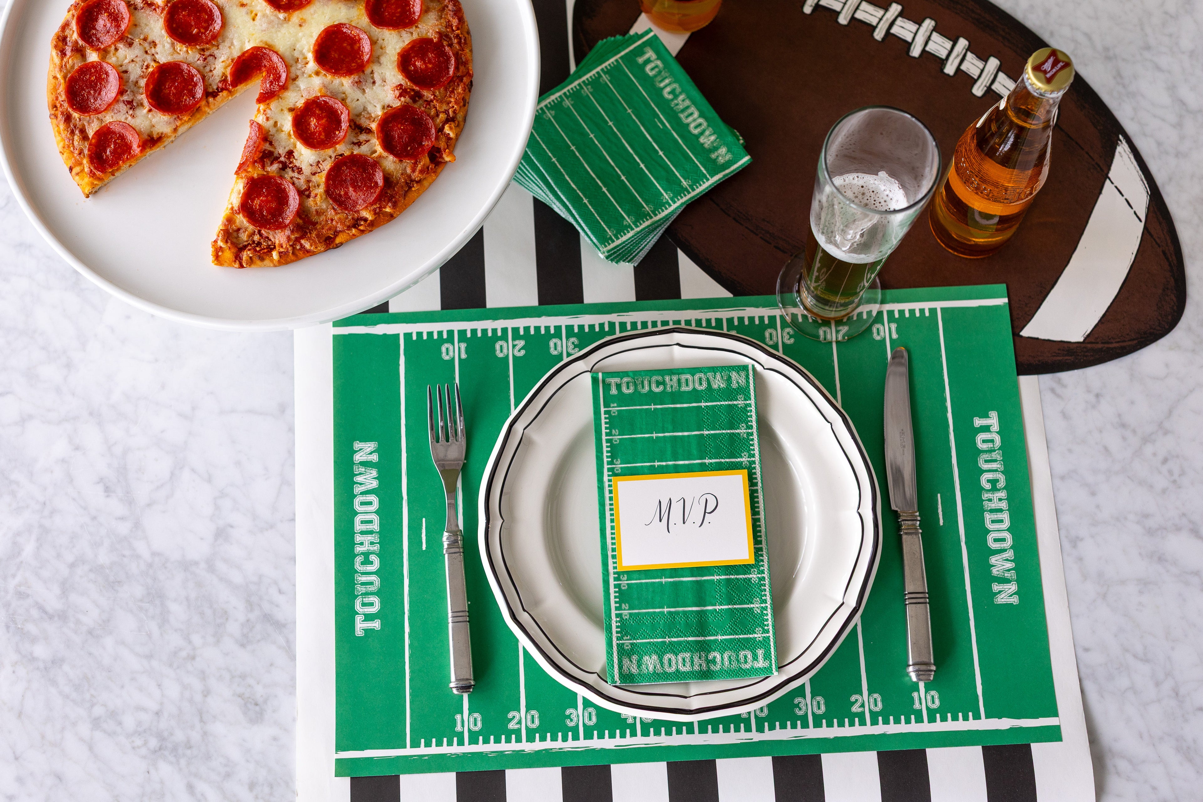 A tailgate themed table setting featuring the Touchdown Placemat and napkins and Die-cut Football Placemat.