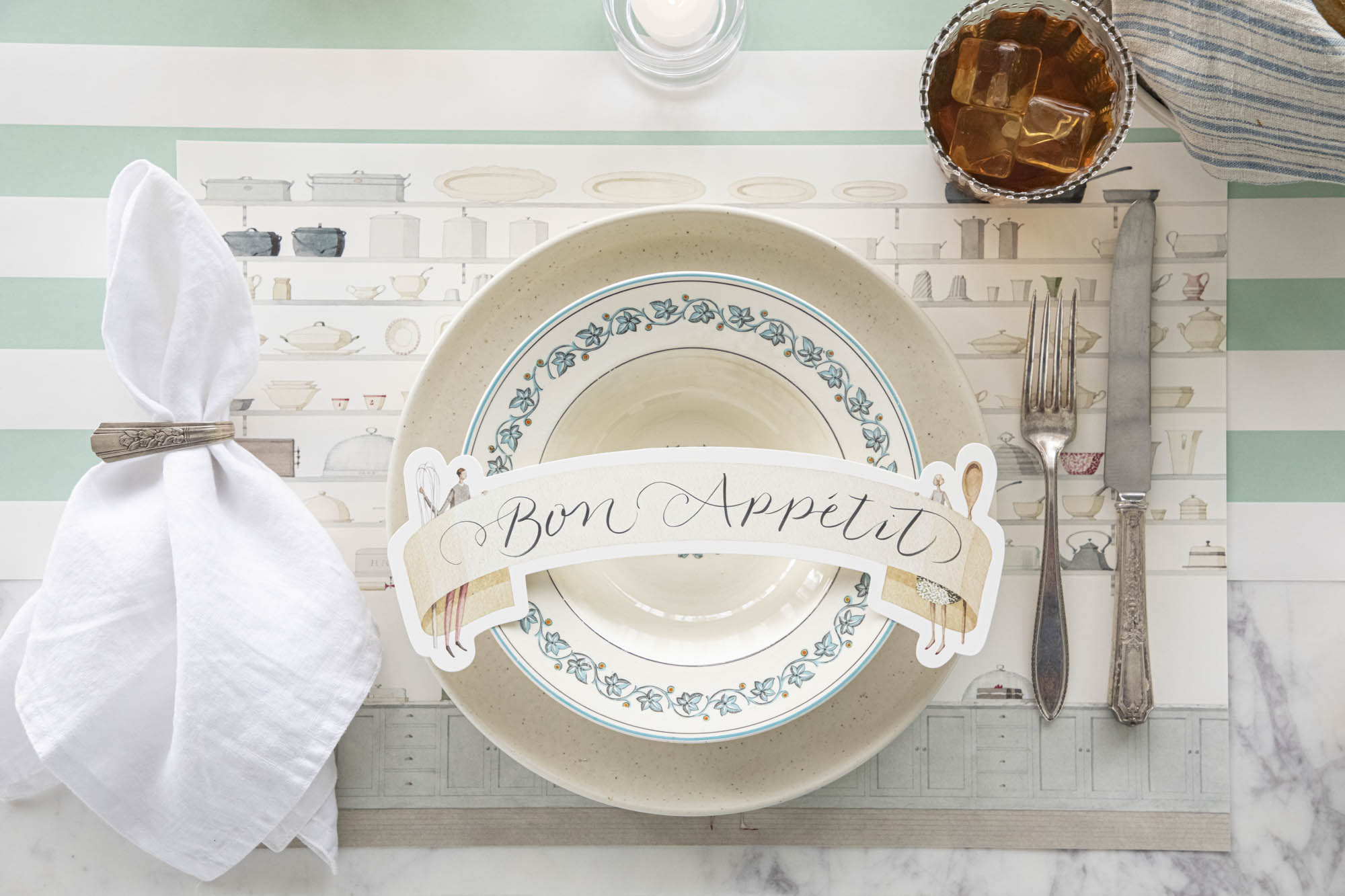 Butler's Pantry Placemat under a classic place setting with the Two Cooks Banner Table Accent resting on the plates.
