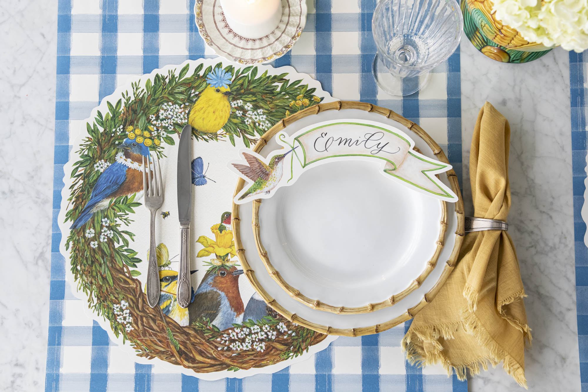 An elegant place setting featuring Vicki Sawyer's Die-cut Songbird Wreath Placemat and Hummingbird Table Accent.