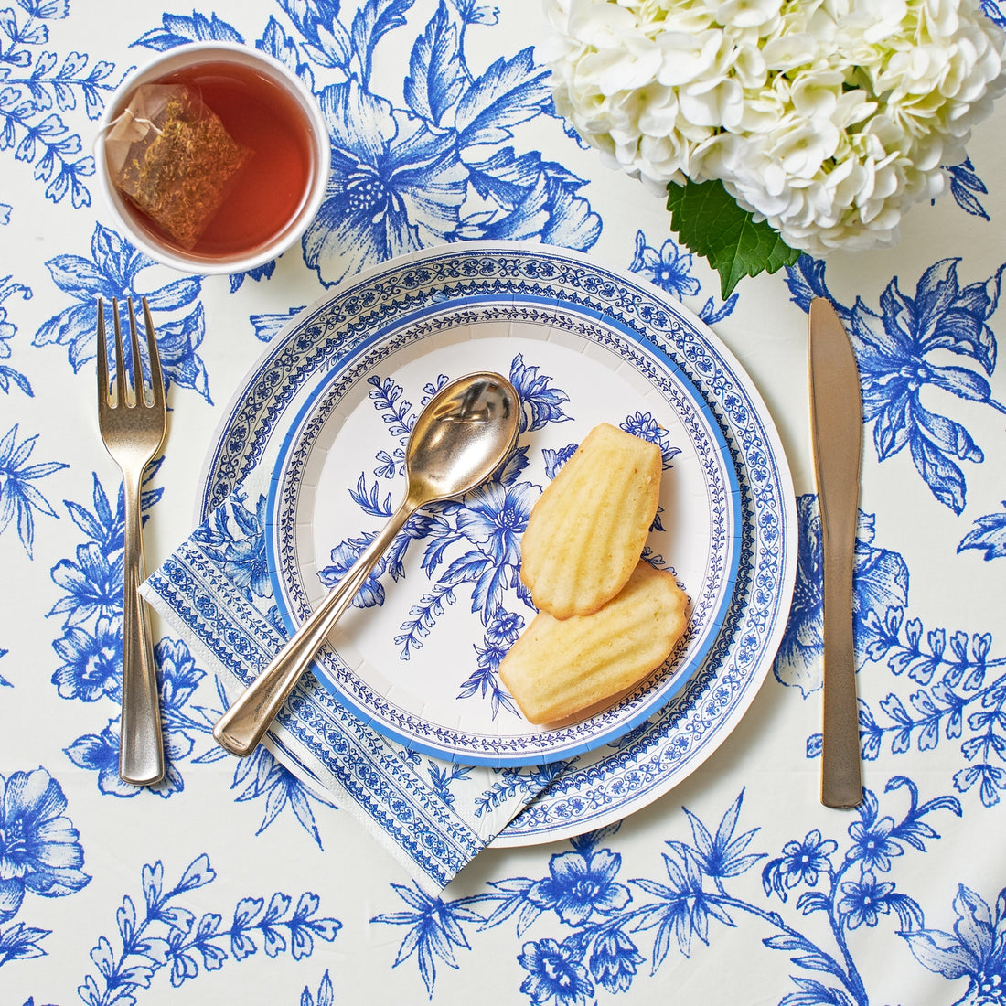 Blue French Toile Paper Tablecloth on a table with coordinating plates. 