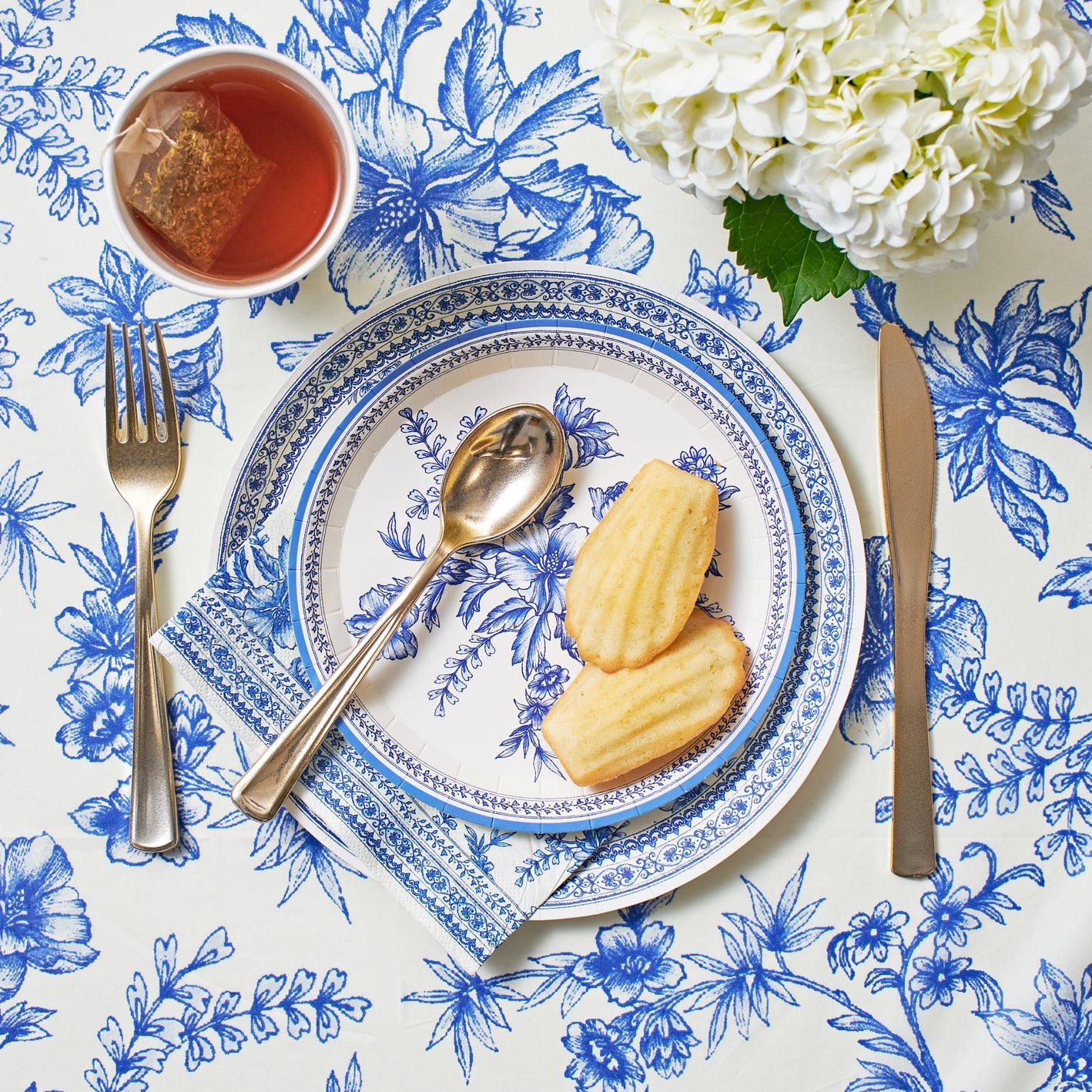 Blue French Toile Paper Tablecloth on a table with coordinating plates. 