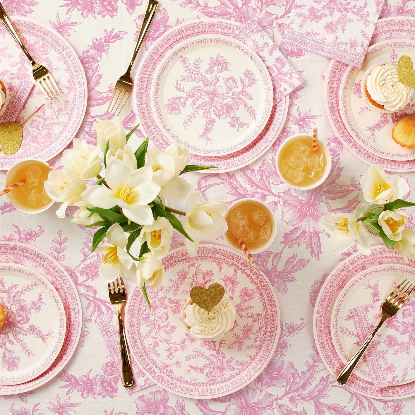 Pink French Toile Paper Tablecloth on a table with coordinating plates. 