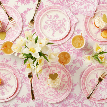 Pink French Toile Paper Tablecloth on a table with coordinating plates. 