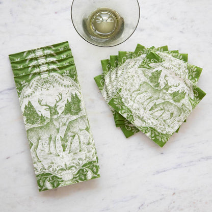A stack of Fable Toile Guest Napkins and a fanned-out stack of Fable Toile Cocktail Napkins on a table next to a wine glass, from above.
