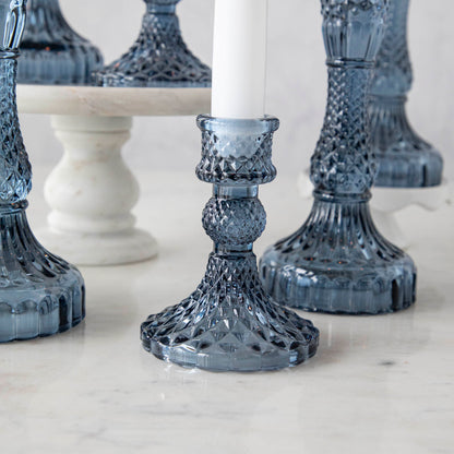 A group of Accent Decor Vintage Blue Candlestick candle holders on a marble table.