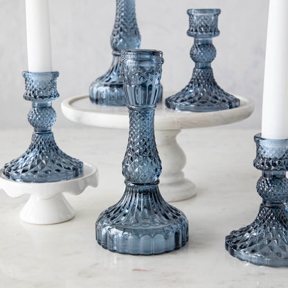 A group of Accent Decor Vintage Blue Candlestick candle holders on a marble table.