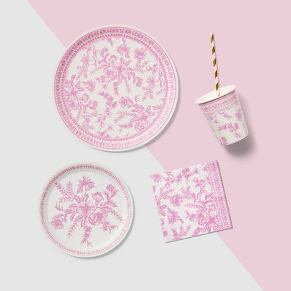 A table set with Pink French Toile Paper Party Dinnerware plates from Coterie Party Supplies featuring floral toile dinnerware patterns that evoke the charm of the French countryside, complemented by silverware.