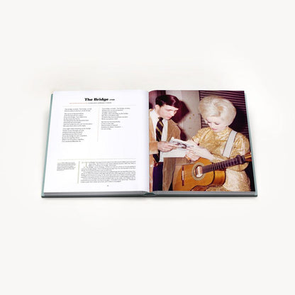 Two hardcover books titled &quot;Songteller: My Life in Lyrics&quot; by Dolly Parton, displayed with the front cover and spine visible, featuring images and text related to Dolly Parton&