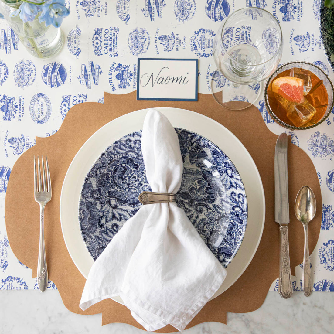 Burleigh Heritage Runner under the Kraft French Frame Placemat with an elegant place setting on top.