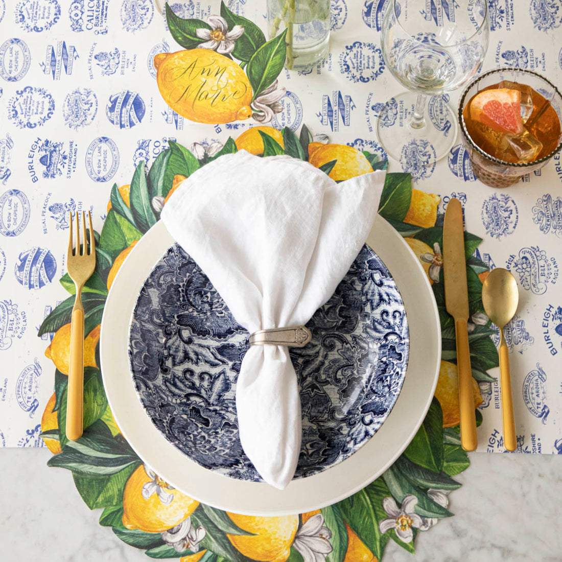 Die-cut Lemon Wreath Placemat with an elegant place setting on top and Burleigh Heritage Runner underneath.