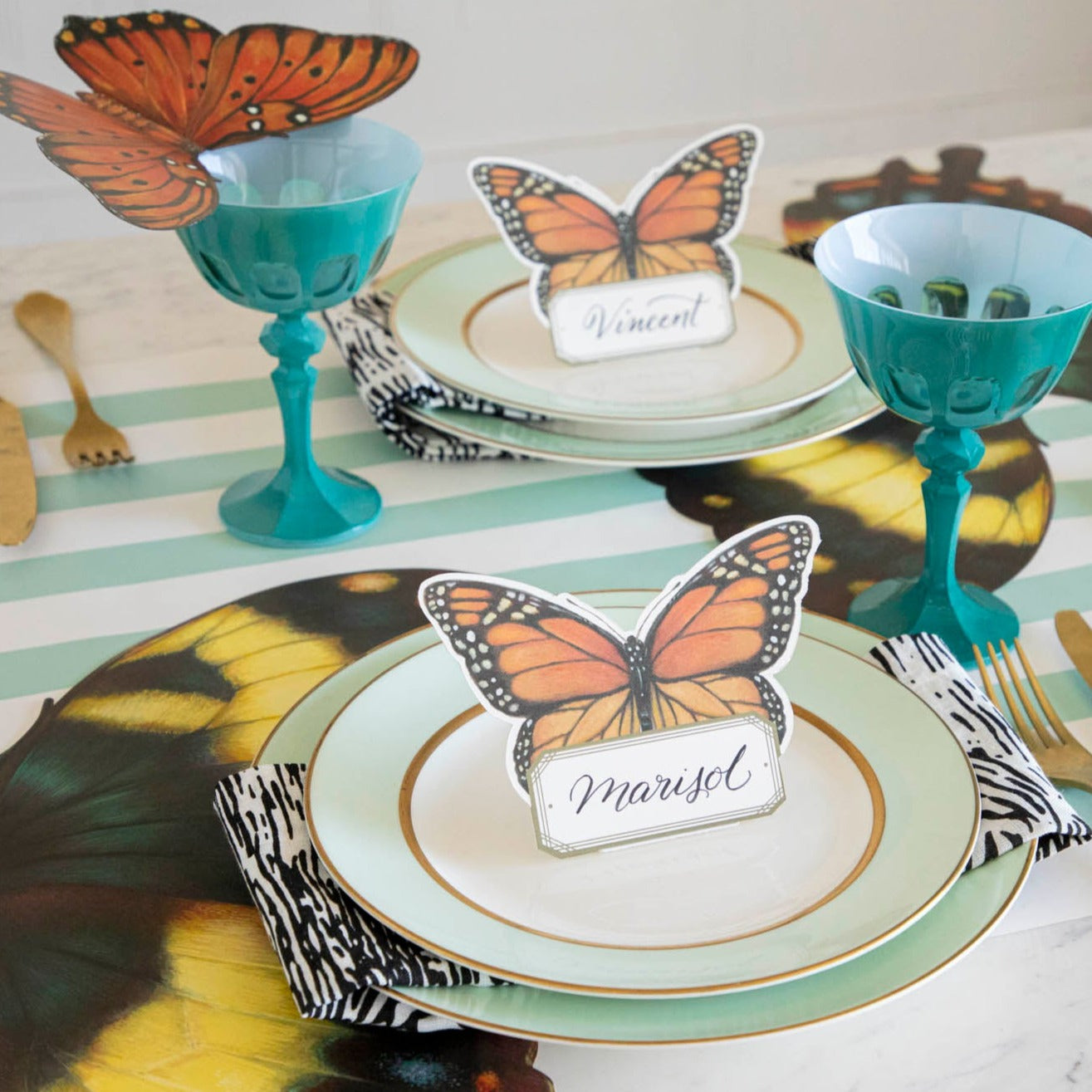 An elegant butterfly-themed tablescape featuring Monarch Butterfly Place Cards standing on each plate.