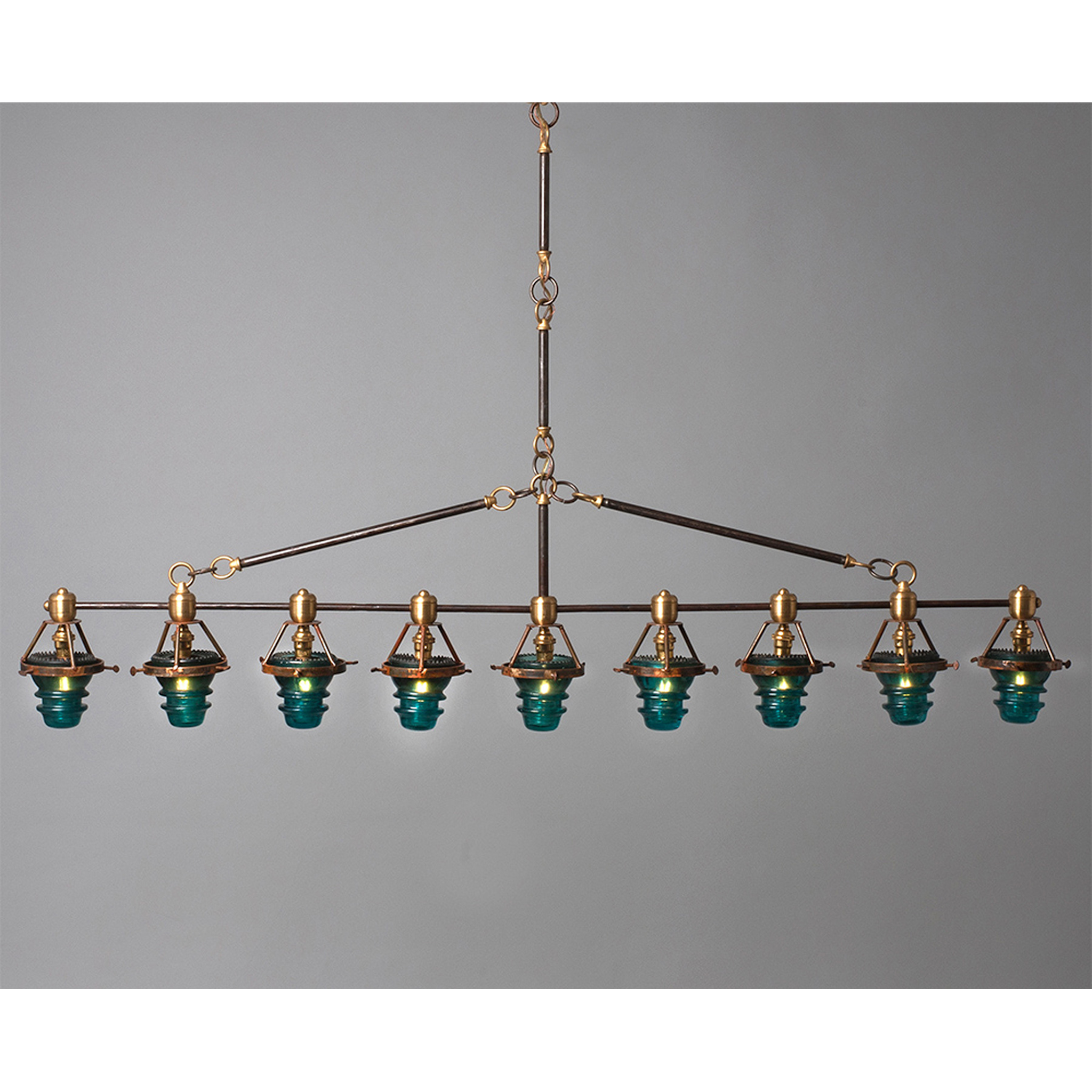 A Telegraph Pendant Lighting with four glass shades and antique insulators hanging from a brass frame. (Brand Name: Hester &amp; Cook)