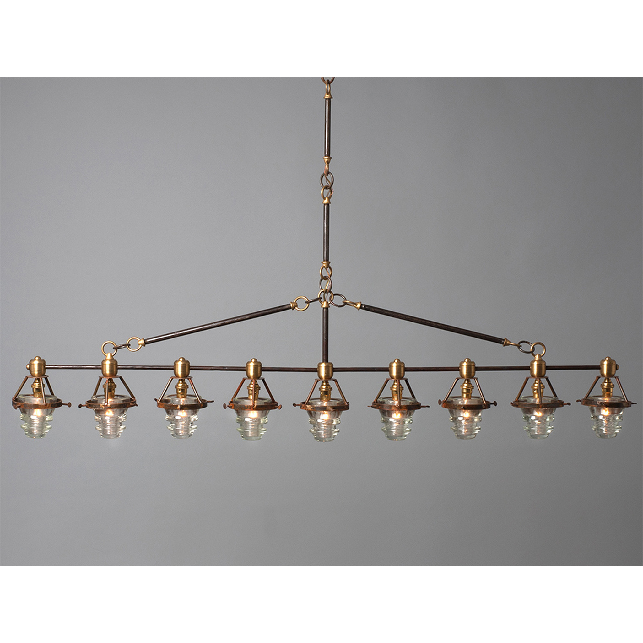 A Telegraph Pendant Lighting with four glass shades and antique insulators hanging from a brass frame. (Brand Name: Hester &amp; Cook)