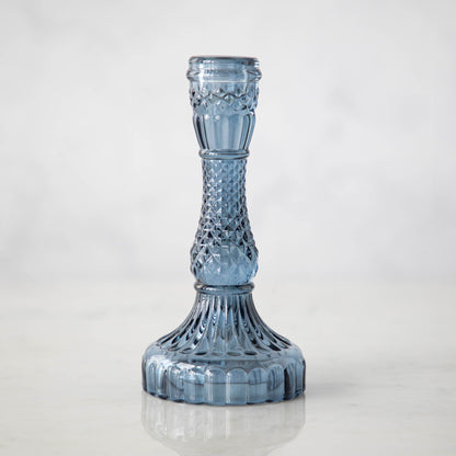 A group of Accent Decor Vintage Blue Candlestick candle holders on a marble table.